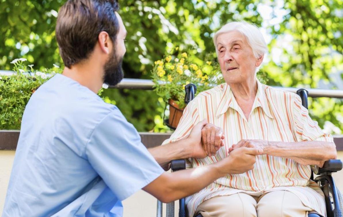 Carer attending to elderly man