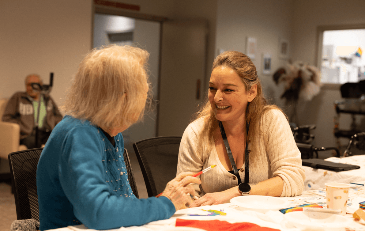 Elderly lady chatting to carer at lunch time