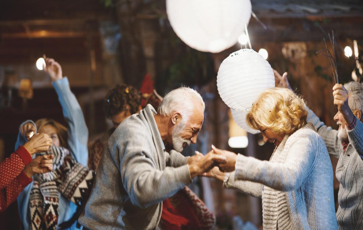 An elderly couple dancing in what appears to be a family party.