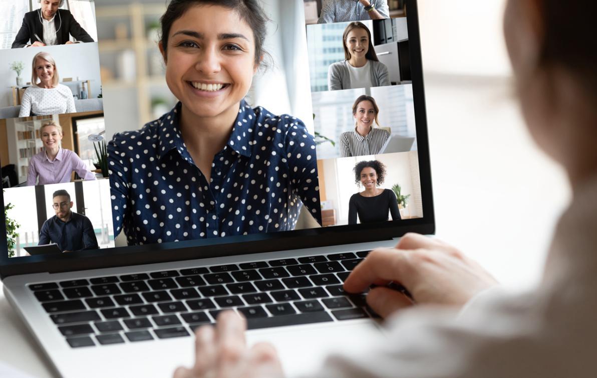 A person sitting at their laptop on a video call with several people