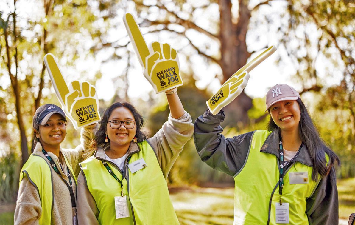 Three volunteers wearing high visibility yellow vests for Memory Walk and Jog