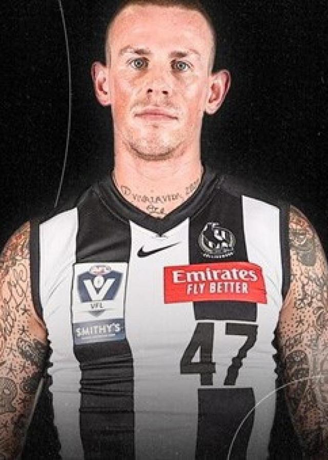 Fornmer AFL footballer Ben Crocker staring at the camera wearing a Collingwood football jumper.